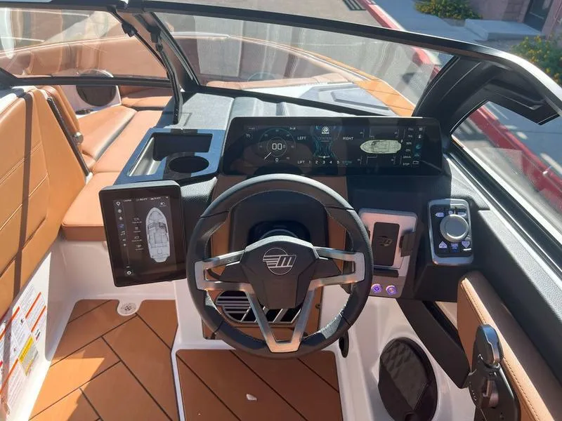 Slide: The Image of 2025 Malibu 23 LSV boat dashboard with modern controls and leather seating. - 20