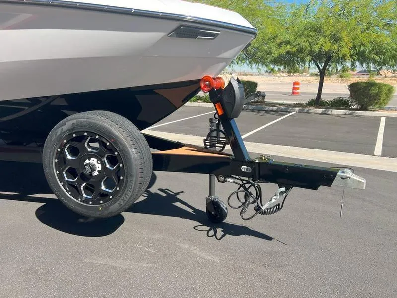 Slide: The Image of 2025 Malibu 23 LSV boat on trailer in parking lot, sunny day. - 21