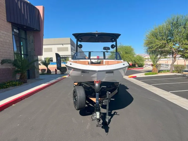 Slide: The Image of 2025 Malibu 23 LSV boat on trailer in sunny parking lot. - 26