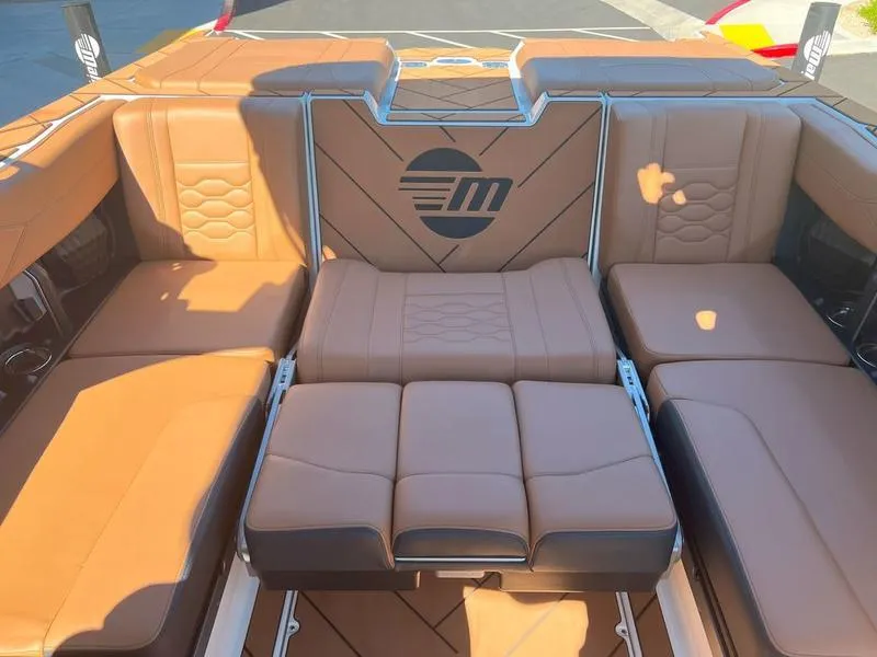 Slide: The Image of 2025 Malibu 23 LSV boat interior with tan leather seating and logo. - 31