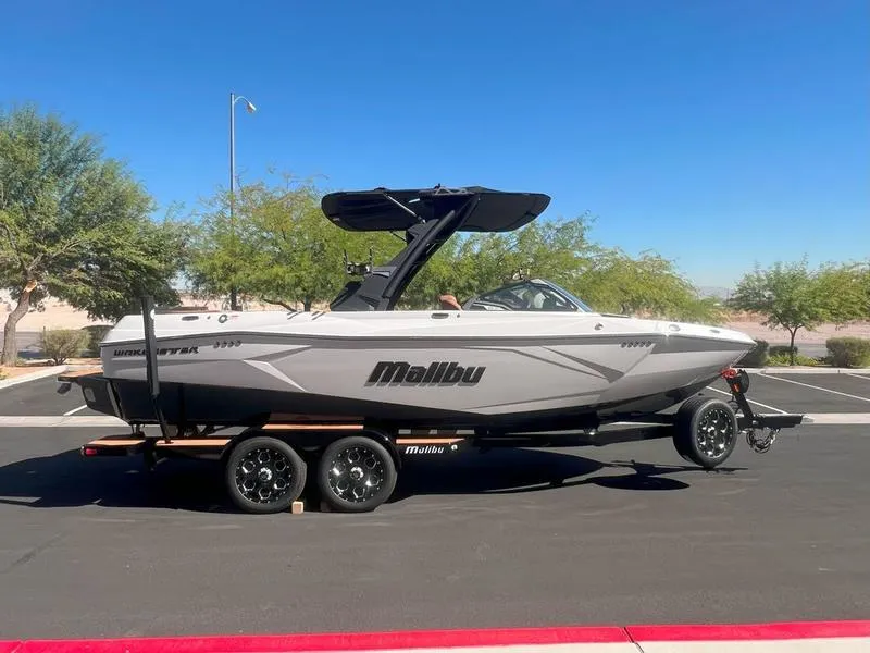 Slide: The Image of 2025 Malibu 23 LSV boat on trailer in sunny parking lot. - 5
