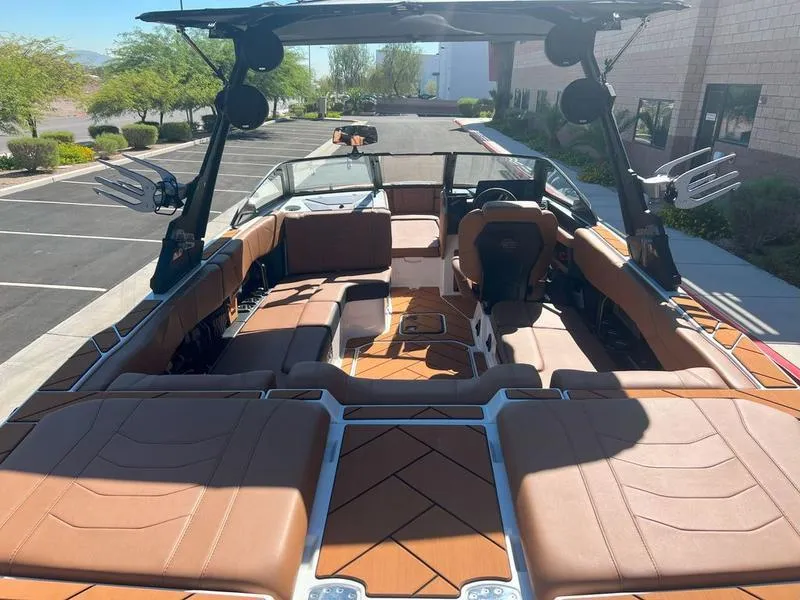 Slide: The Image of 2025 Malibu 23 LSV boat interior with brown leather seating and modern design. - 7