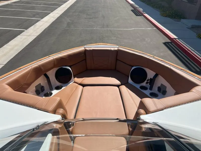 Slide: The Image of 2025 Malibu 23 LSV boat interior with tan seating and built-in speakers. - 9
