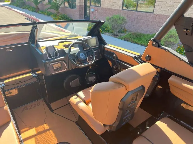 Slide: The Image of 2025 Axis A225 boat interior with tan seats and modern dashboard. - 11