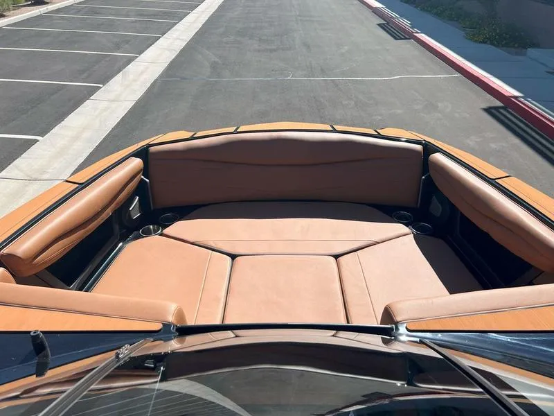 Slide: The Image of 2025 Axis A225 boat interior with tan leather seating and cup holders. - 12