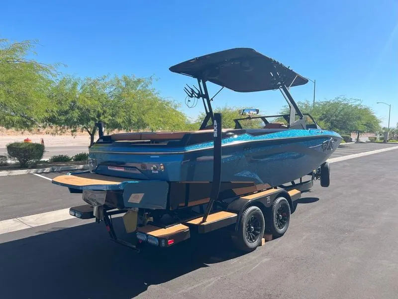 Slide: The Image of 2025 Axis A225 boat on trailer, blue exterior, parked on sunny street. - 5