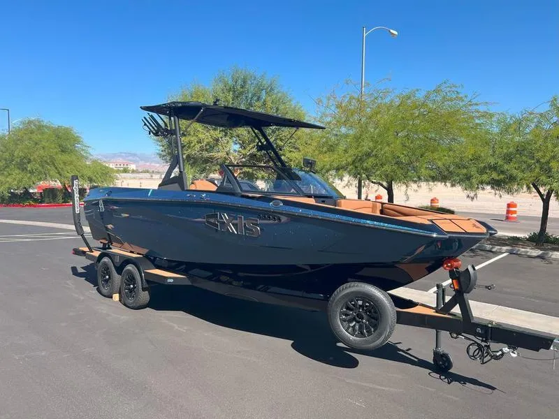 Slide: The Image of 2025 Axis A225 boat on trailer, parked on sunny street with trees in background. - 7