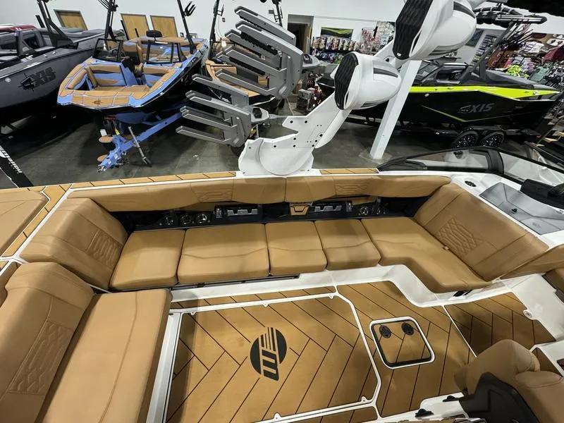Slide: The Image of 2024 Malibu 25 LSV boat interior with tan seating and sleek design. - 4