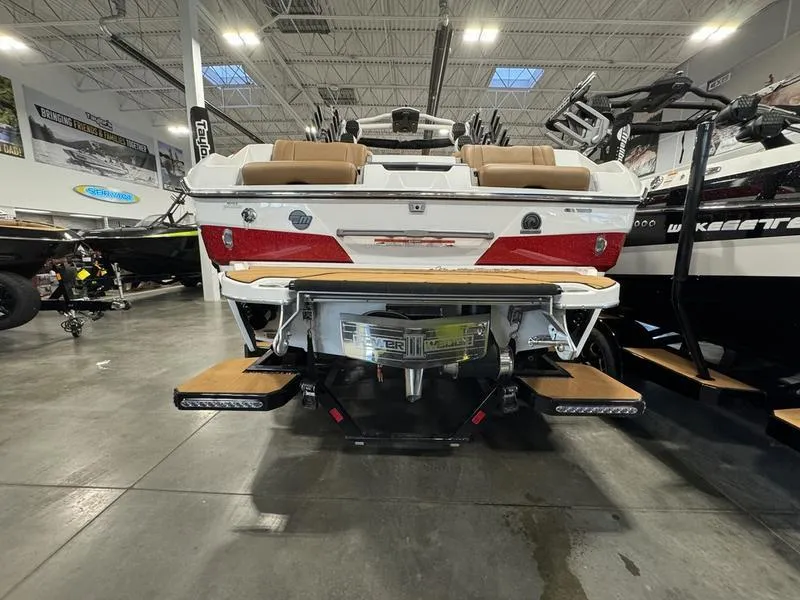 Slide: The Image of 2024 Malibu 25 LSV boat in showroom, rear view with seating and swim platform. - 7