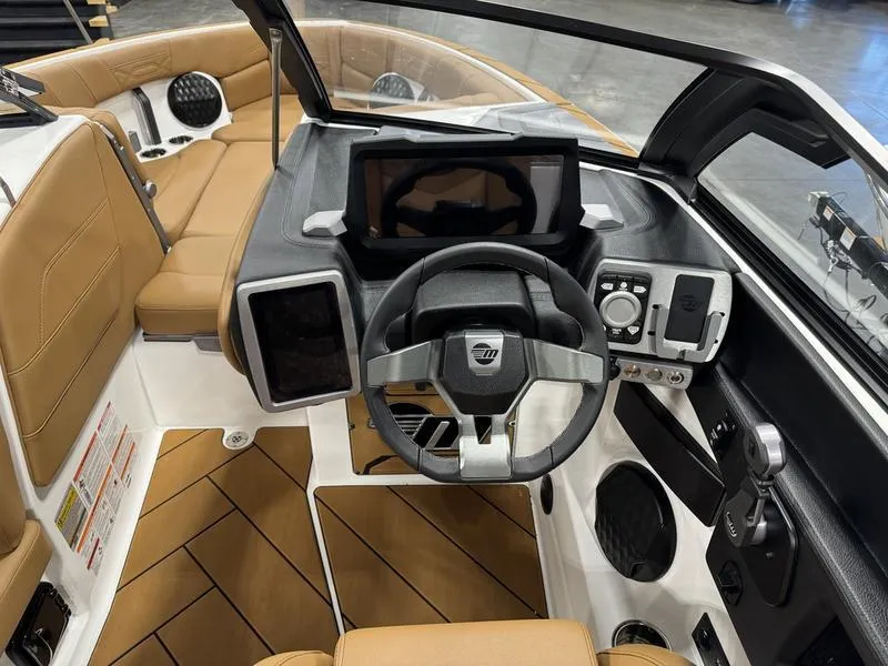 Slide: The Image of 2024 Malibu 25 LSV boat interior with modern dashboard and tan seating. - 9
