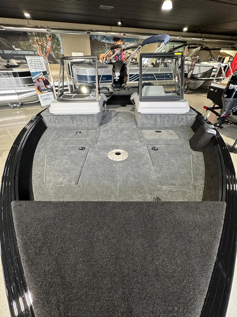 Slide: The Image of 2025 Smoker Craft Adventurer 188 DC boat interior with seating and carpeted deck. - 2