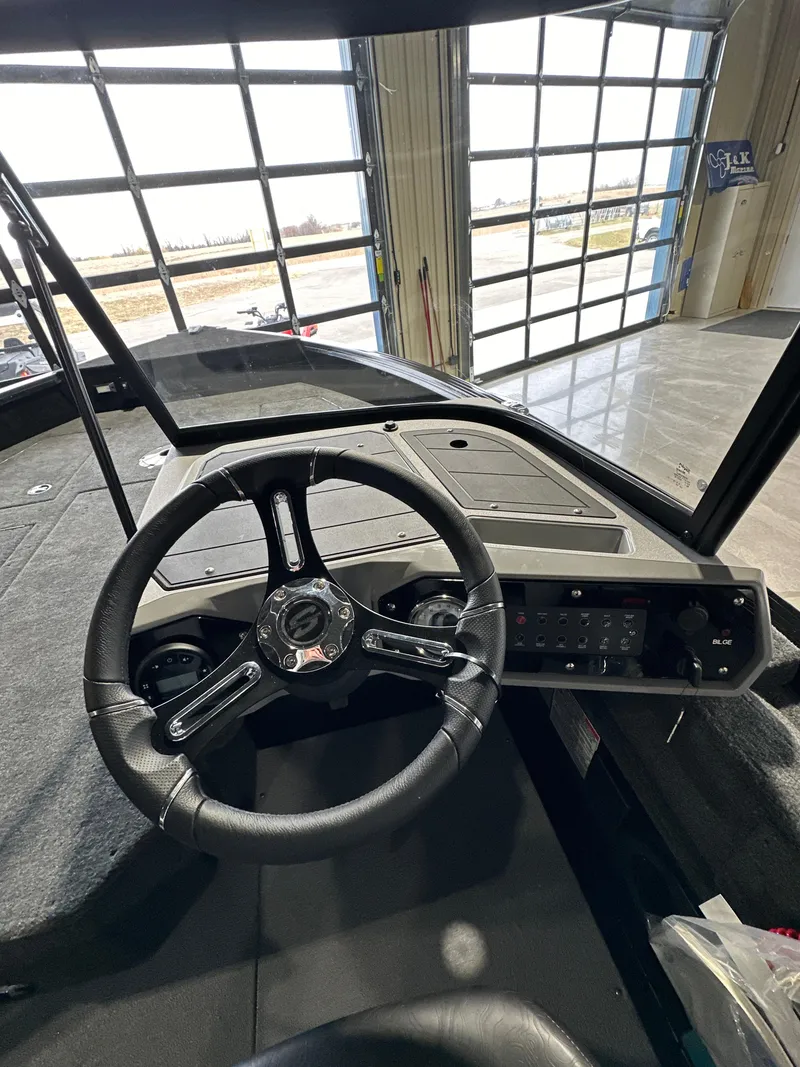 Slide: The Image of 2025 Smoker Craft Adventurer 188 DC boat dashboard with steering wheel in a showroom. - 9