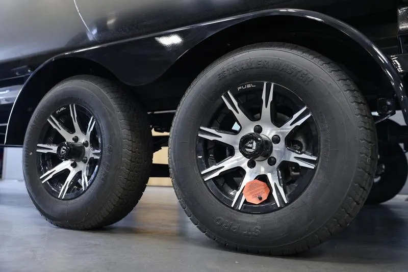 Slide: The Image of 2024 Barletta ARIA A22UC trailer wheels, black and silver design, close-up view. - 12