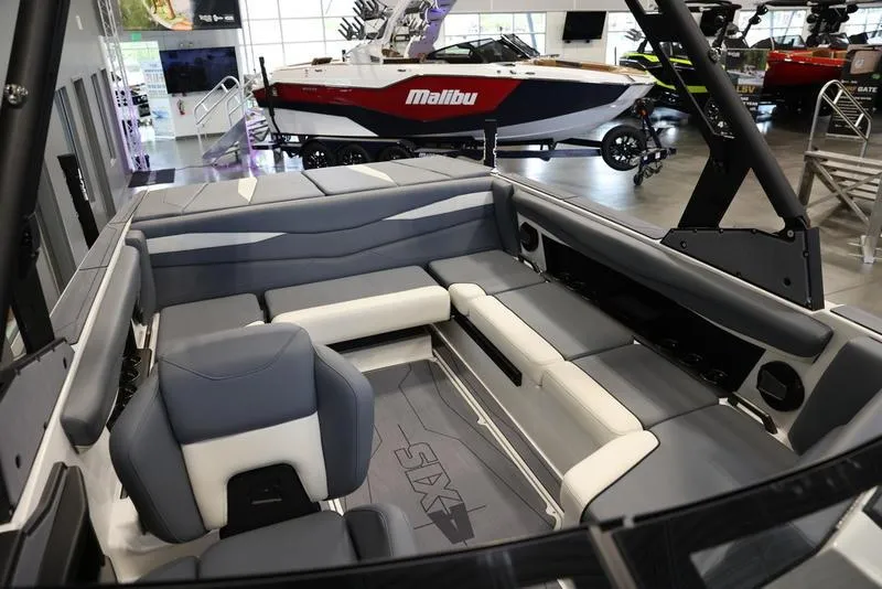 Slide: The Image of 2024 Axis A225 boat interior with gray and white seating in showroom. - 11