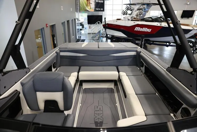 Slide: The Image of 2024 Axis A225 boat interior with gray and white seating in showroom. - 3