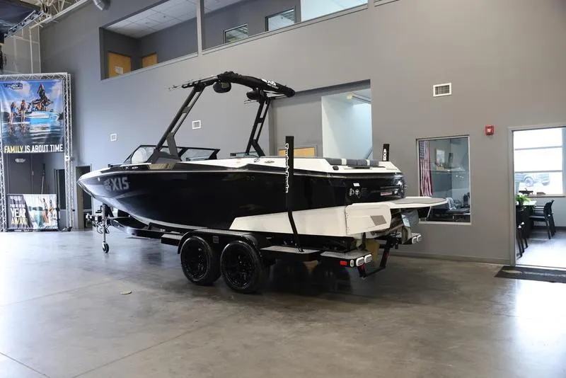 Slide: The Image of 2024 Axis A225 boat in showroom, black and white design, on trailer. - 5