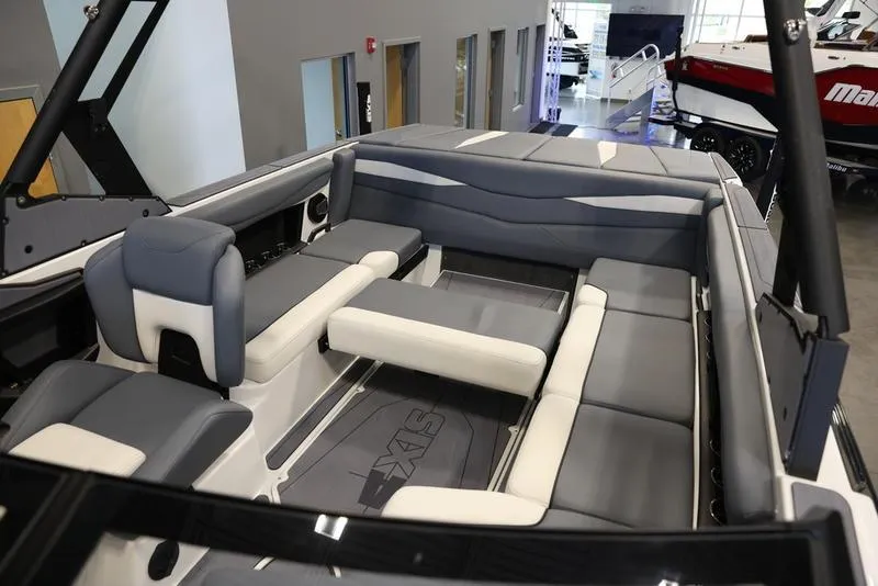 Slide: The Image of 2024 Axis A225 boat interior with gray and white seating in showroom. - 9