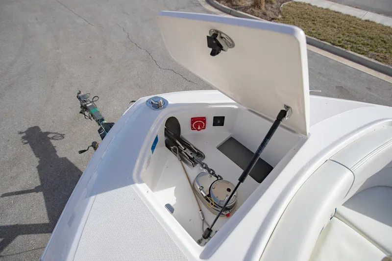 Slide: The Image of 2022 Regal 2800 Bowrider anchor storage compartment open, showing anchor and equipment. - 33