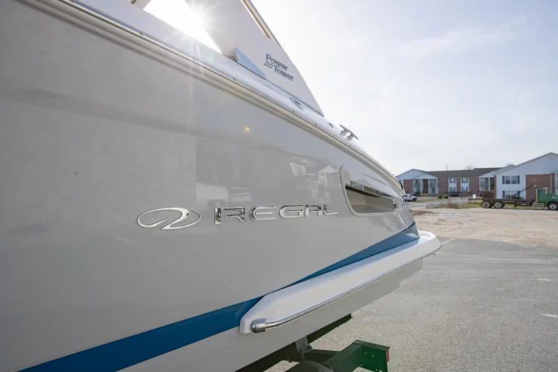 Slide: The Image of 2022 Regal 2800 Bowrider boat, side view with logo, parked outdoors. - 4