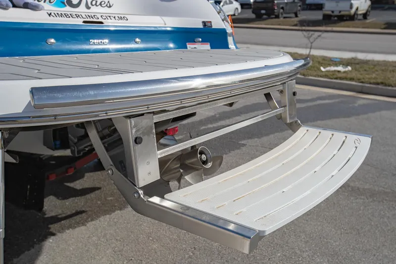Slide: The Image of 2022 Regal 2800 Bowrider swim platform with stainless steel details in a parking area. - 8