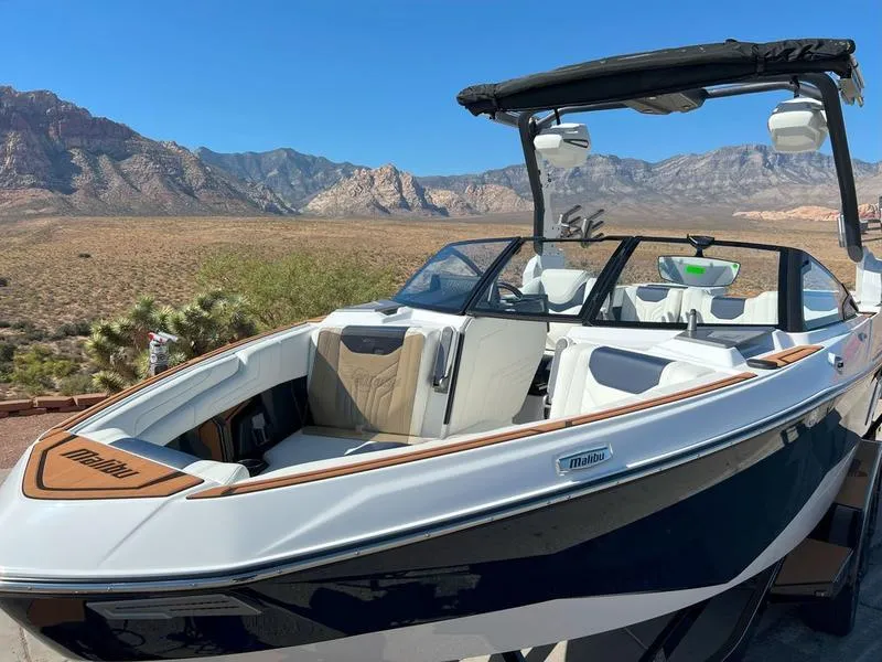 Slide: The Image of 2025 Malibu 25 LSV boat with sleek design in scenic mountain backdrop. - 11