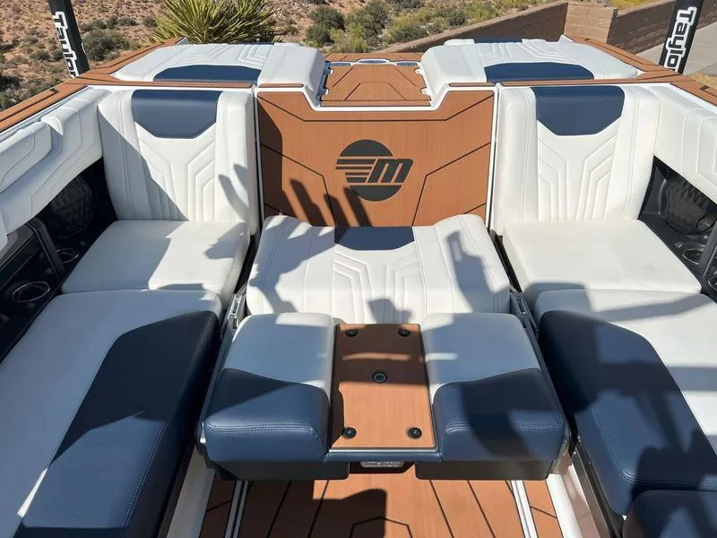 Slide: The Image of 2025 Malibu 25 LSV boat interior with luxurious white and navy seating. - 13