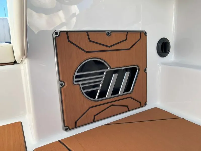 Slide: The Image of 2025 Malibu 25 LSV boat interior with stylish wood paneling and logo detail. - 14