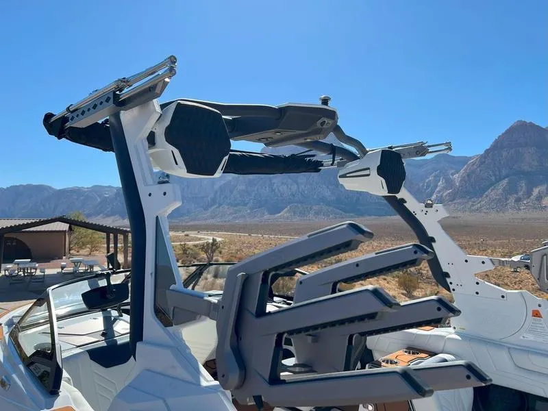 Slide: The Image of 2025 Malibu 25 LSV boat with advanced wakeboard tower in scenic mountain setting. - 17