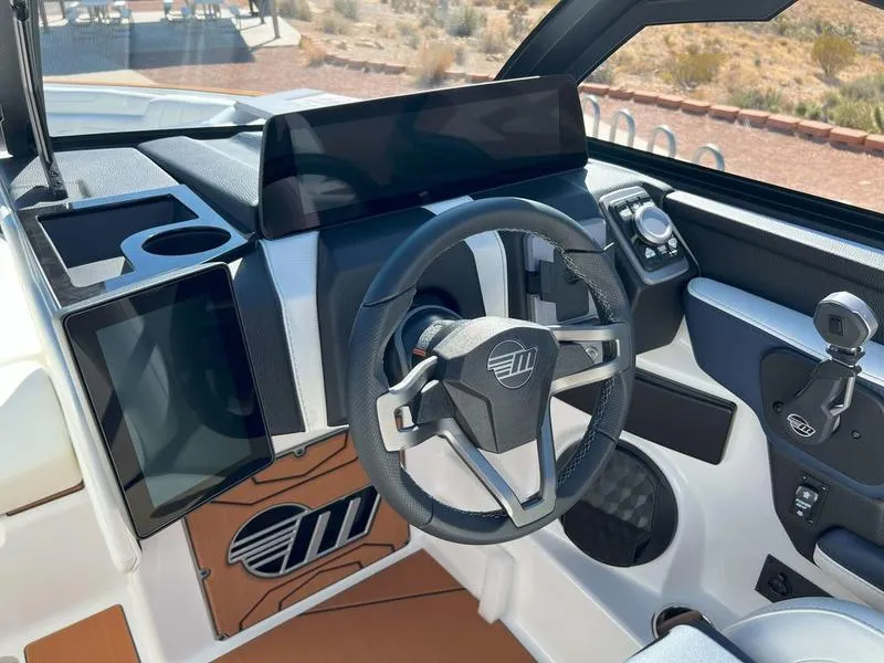 Slide: The Image of 2025 Malibu 25 LSV boat dashboard with steering wheel and digital display. - 18