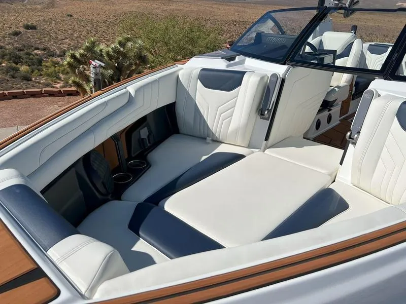 Slide: The Image of Luxurious interior of 2025 Malibu 25 LSV boat with white and navy seating. - 21