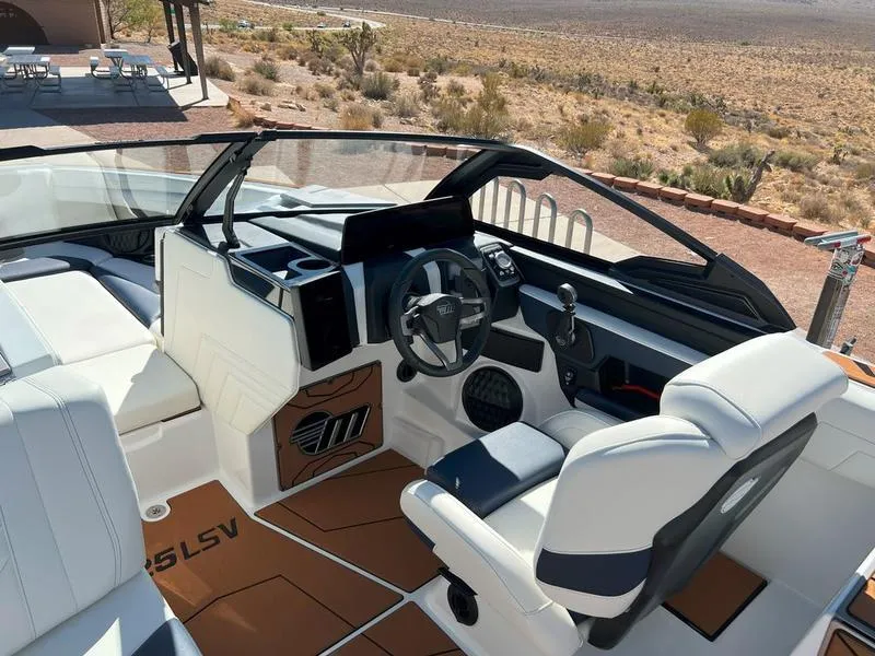 Slide: The Image of 2025 Malibu 25 LSV boat interior with modern dashboard and seating. - 25