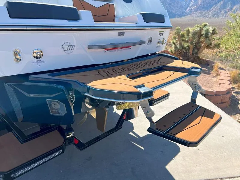Slide: The Image of 2025 Malibu 25 LSV boat with teak swim platform in desert landscape. - 7
