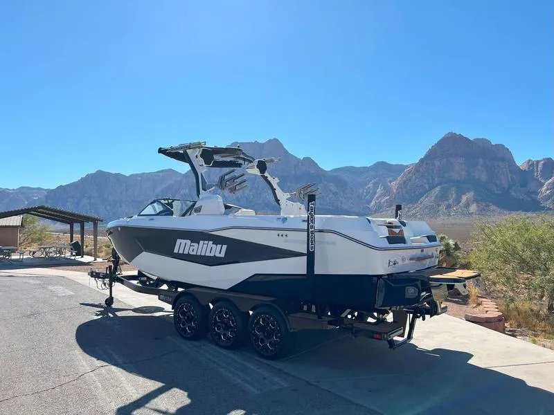 Slide: The Image of 2025 Malibu 25 LSV boat on trailer, scenic mountain backdrop, sunny day. - 8