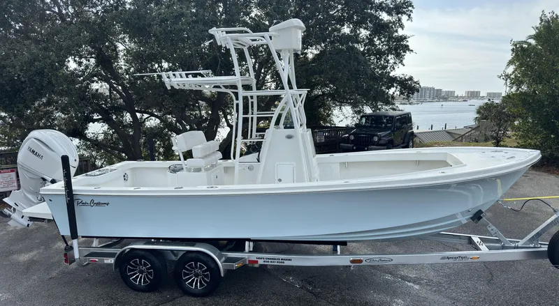 The Image of 2025 Pair Customs 24DV boat on trailer, parked near waterfront. - 0