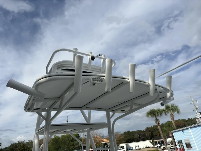 Slide: The Image of 2025 Pair Customs 24DV boat with rod holders against a cloudy sky. - 6