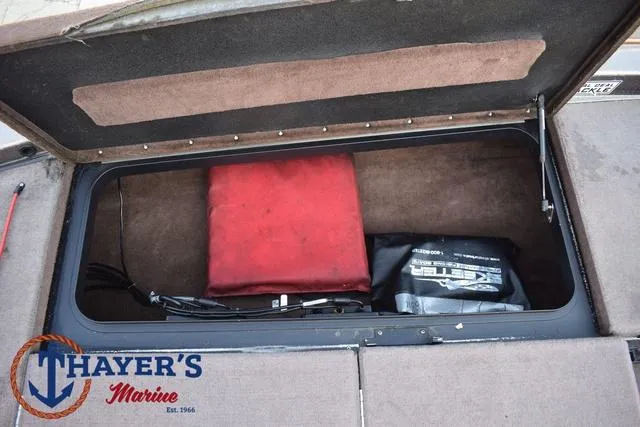 Slide: The Image of Open storage compartment in 2010 Skeeter ZX225 boat with red and black bags. - 15