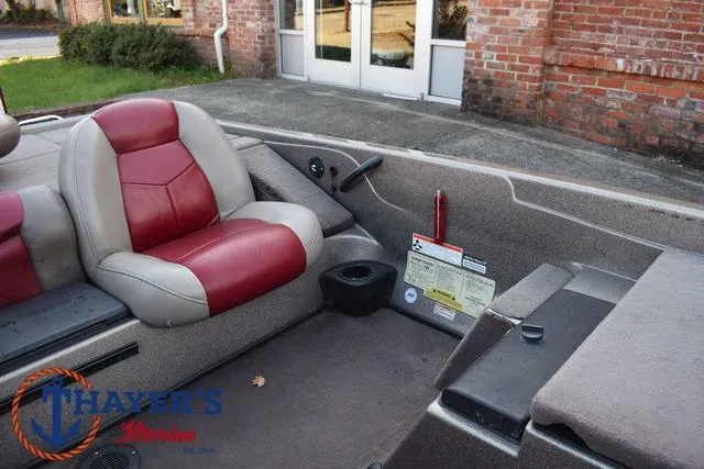 Slide: The Image of 2010 Skeeter ZX225 boat interior with red and gray seating, cup holder, and control panel. - 20