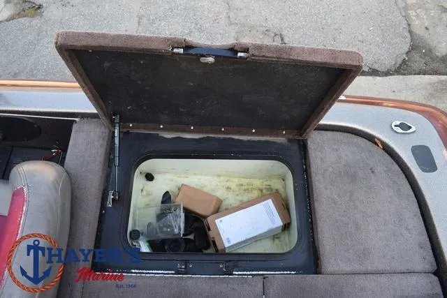 Slide: The Image of Open storage compartment on 2010 Skeeter ZX225 boat with various items inside. - 34