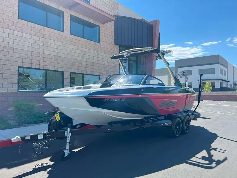 Slide: The Image of 2021 Malibu 22 LSV boat on trailer in parking lot, sunny day. - 1