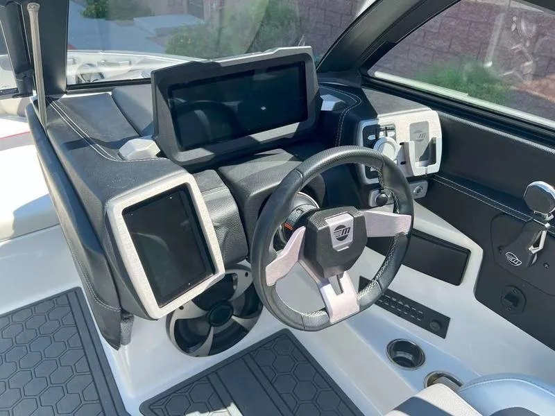 Slide: The Image of 2021 Malibu 22 LSV boat dashboard with modern controls and touchscreen displays. - 13