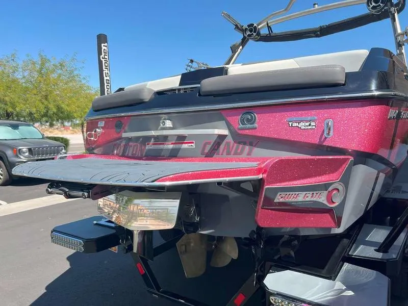 Slide: The Image of 2021 Malibu 22 LSV boat, rear view, red finish, parked outdoors. - 5