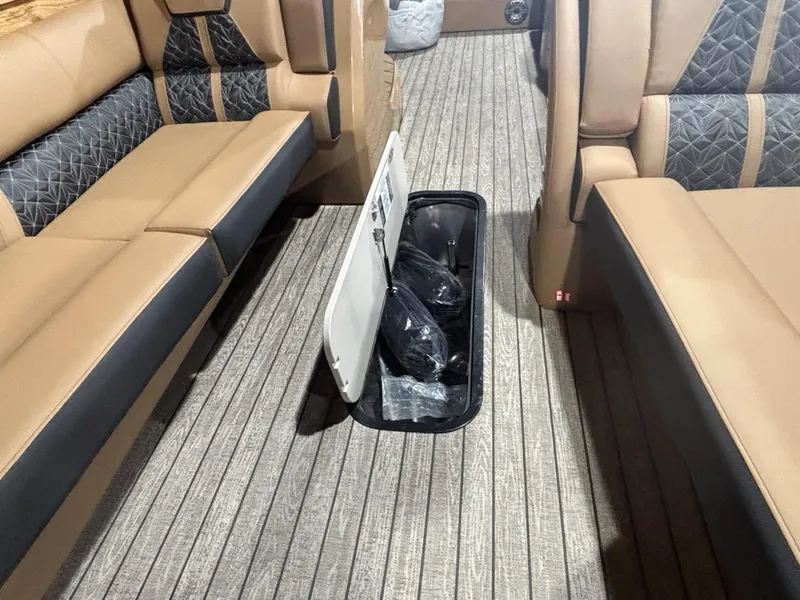 Slide: The Image of 2025 Harris Grand Mariner 250 SLEC interior with tan seating and storage compartment. - 11