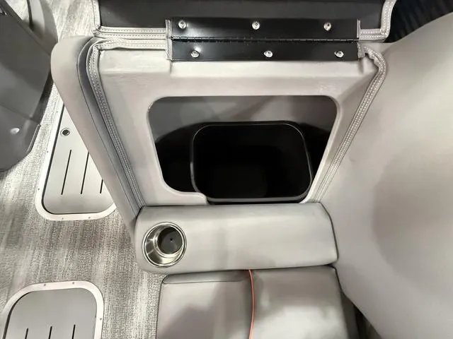 Slide: The Image of Bennington L Swingback 23 LSBA 2025 boat interior with cup holder and storage compartment. - 11