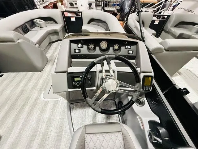 Slide: The Image of 2025 Bennington L Swingback 23 LSBA boat interior with modern steering and seating. - 17