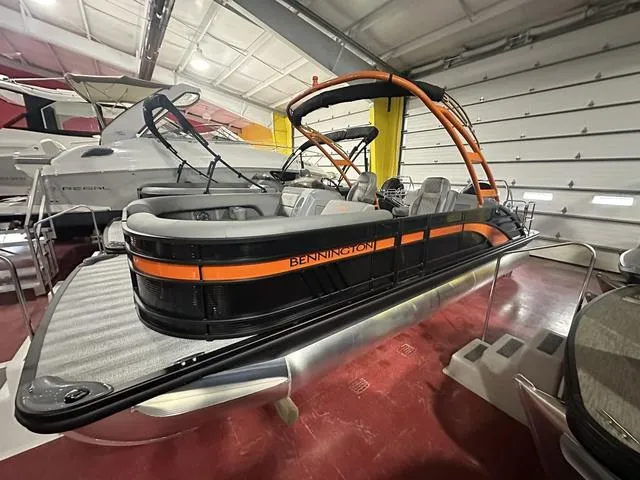 Slide: The Image of 2025 Bennington L Swingback 23 LSBA pontoon boat in showroom, featuring sleek design and vibrant colors. - 21