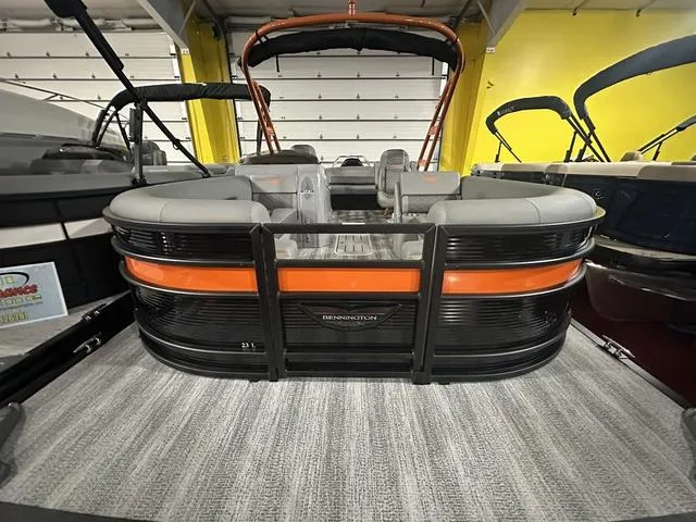 Slide: The Image of 2025 Bennington L Swingback 23 LSBA pontoon boat in showroom, featuring sleek design and comfortable seating. - 22
