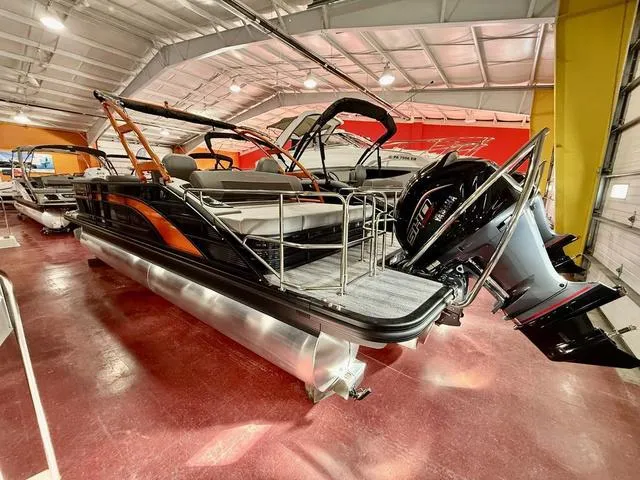 Slide: The Image of 2025 Bennington L Swingback 23 LSBA pontoon boat in showroom, featuring sleek design and powerful engine. - 6
