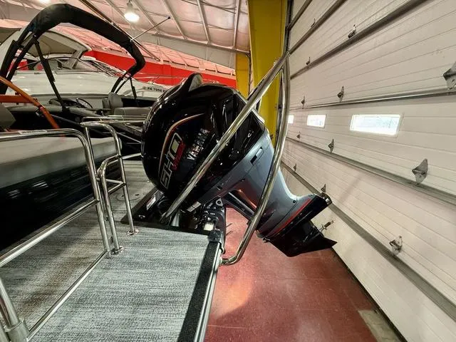 Slide: The Image of 2025 Bennington L Swingback 23 LSBA with powerful outboard motor in a showroom. - 7