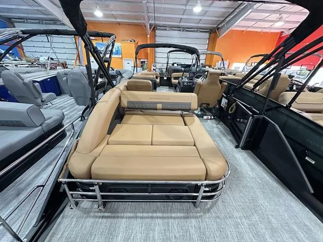 Slide: The Image of 2025 Bennington M Swingback 24 MSB pontoon boat interior with tan seating in showroom. - 15