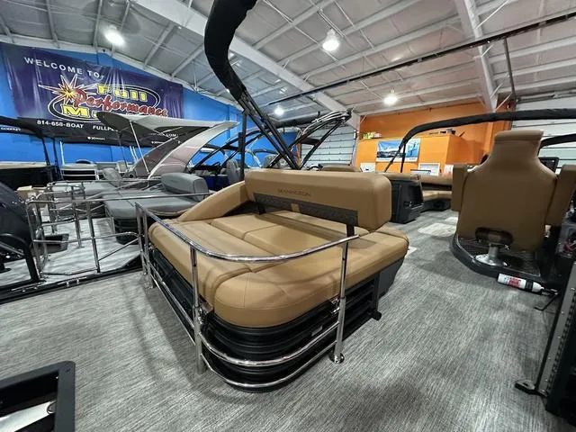 Slide: The Image of 2025 Bennington M Swingback 24 MSB pontoon boat with tan seating in showroom. - 19